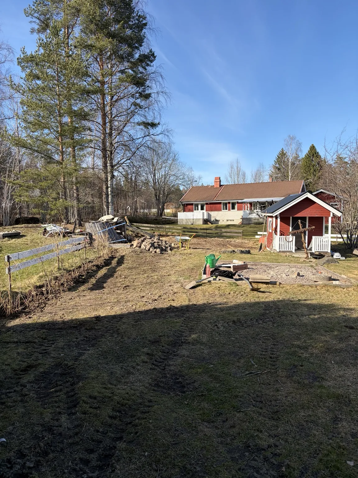 Tomt under mindre markarbete med schaktad yta och rivet staket